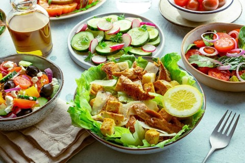 Fresh salads, an assortment. Variety of plates and bowls with green vegetables. Healthy food.