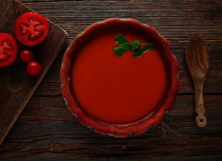 Tomato sauce on clay dish and dark wood background