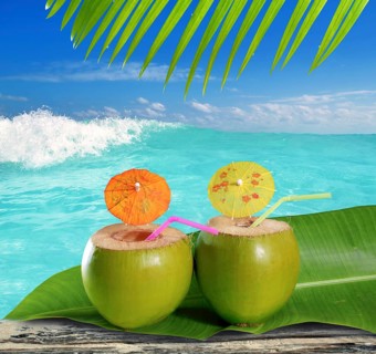 Fresh tender green coconuts straw cocktails on tropical caribbean beach