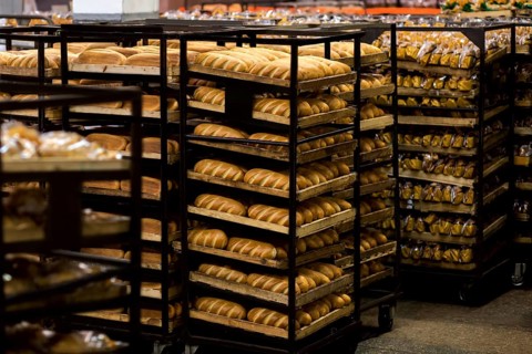 Rack trolley with freshly baked bread at supermarket. Display with fresh bread at bakery shop