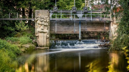 Gundelsheim in Upper Franconia, stream, weir, small bridge with sculpture over a waterfall,