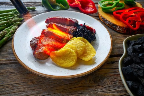 Charcoal grilled beef tenderloin french fries peppers and shallots with blowtorch flame