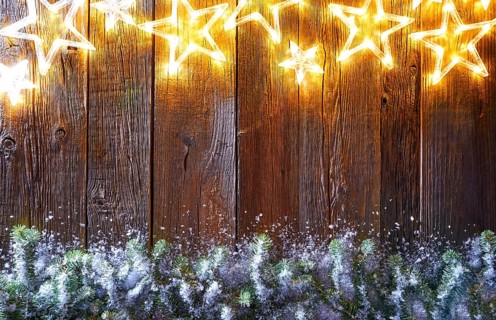 Christmas glowing stars and snow fir on vintage wooden background copy space