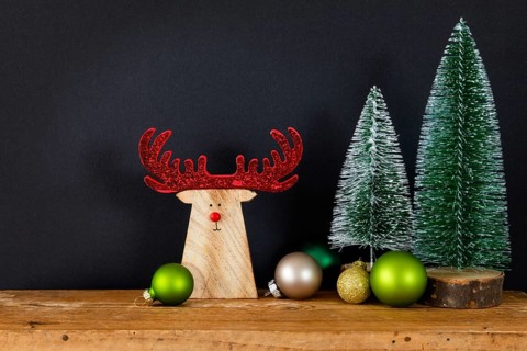 A Christmas decoration black background with tree glass balls and wooden reindeer