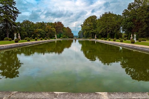 France. Thepossession of Puss in Boots. Huge rectangular swimming pool with a fountain in the park.