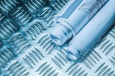 Rolled blueprints on corrugated metal sheet