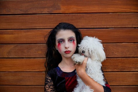 Halloween kid girl custome with bloody makeup on wooden wall
