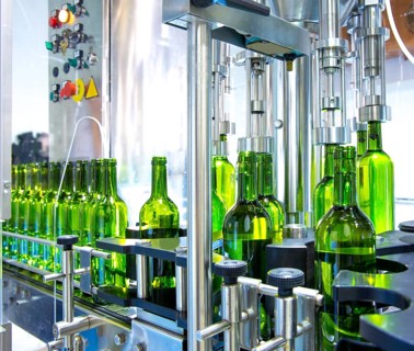 White wine in glass bottling machine at winery