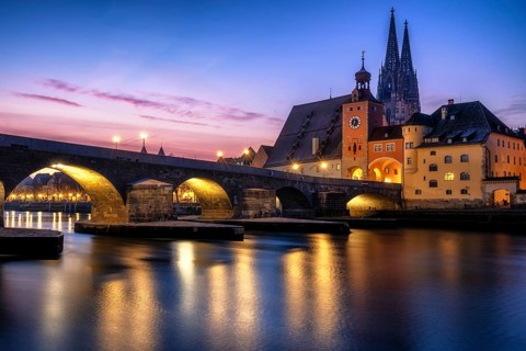 Stone Bridge and St Peter's Cathedral at dusk sunrise in Regensburg with danube