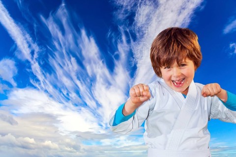 Concept - photo advertising, children, sports. Boy in a white kimono practices judo. Background -