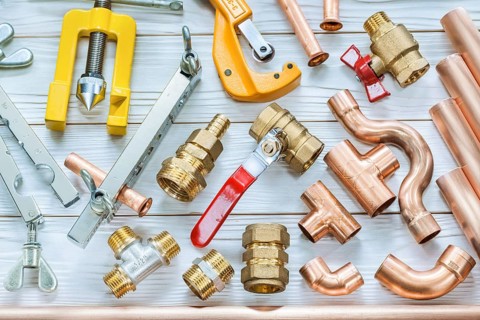 Plumbing tools copper pipes pipe cutter fittings valwes flaring clamps on white wooden boards