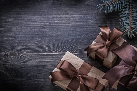 Pine branch packed present box on wooden board holiday concept