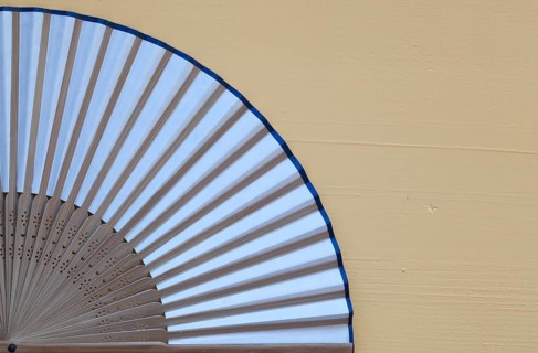 Typical Japanese hand fan made on the wooden yellow table