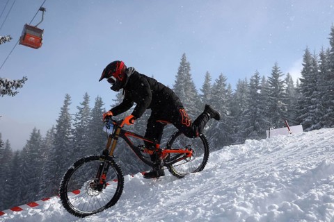 Sofia, Bulgaria - 22 January, 2022: Cyclist rides a bike downhill during an extreme snow riding