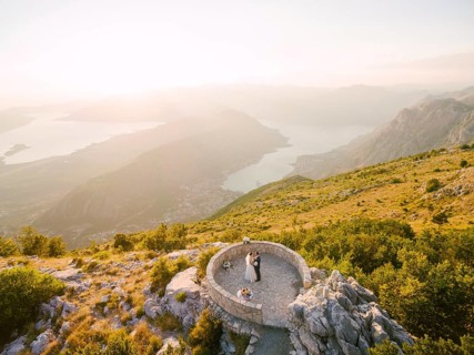 Bride and groom standing on the observation deck on the mountain against the backdrop of the Bay of