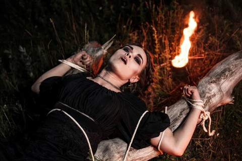 Beautiful young witch in the flames of fire