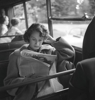 Woman in the 1950s. A young woman on a bus ride spends her time reading a magazine. Sweden 1952.