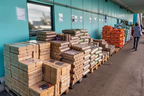 Plastic bags with wood pellets, wood briquettes and firewood at a wholesale market, Allgäu,
