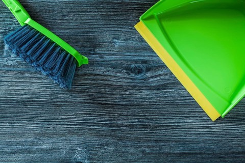 Dustpan and garbage broom set on wooden board