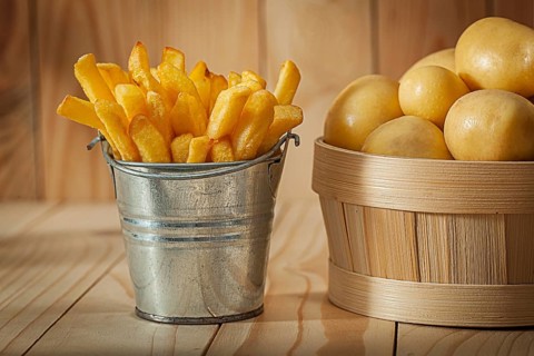 Potato Fries And Whole Potato On Wood Background