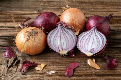 Yellow and red onions on a wooden board