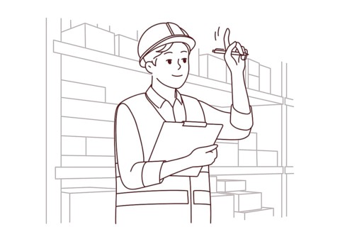 Man in uniform and helmet working in warehouse. Smiling male engineer or mechanic at storehouse or