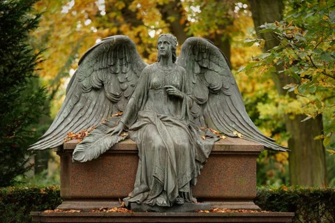 Angel figure with wings at the Melaten cemetery in autumn