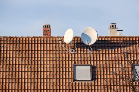 An image of a satellite dish at a roof with space for your text