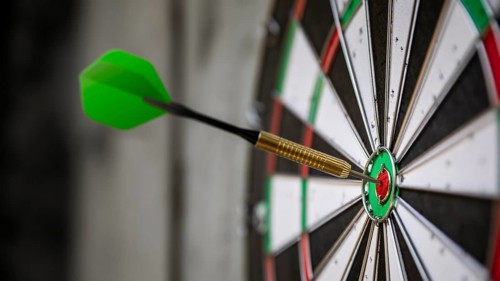 An image of a typical darts game with dart in the bullseye
