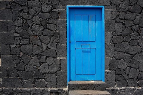 Blue door in black lava stone masonry wall at La Palma Canary Islands