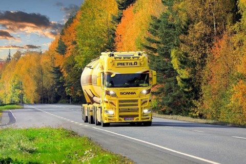 Beautifully customized yellow brown Nextgen Scania tank truck for bulk transport on Highway 10 on a