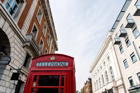 Traditional red telephone box in London, England, UK. Low angle view against sky in Covent Garden