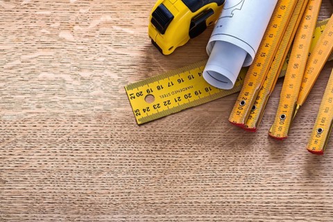 Blueprints and instruments of measurement on oaken wooden board construction concept