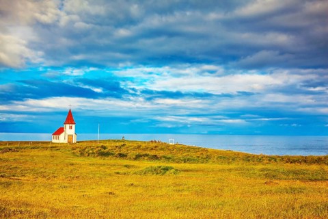 Iceland. White Chapel with red roof on the northern fjord
