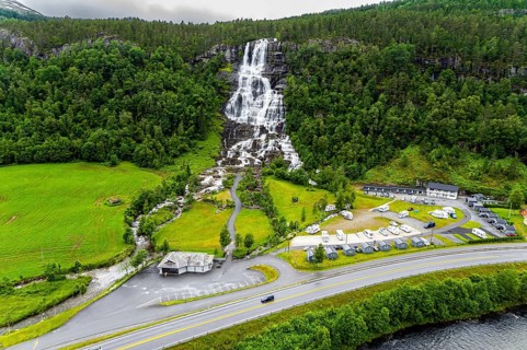 The colossal roaring waterfall Twindefossen. Rainy summer day in the mountains of Norway. Exciting