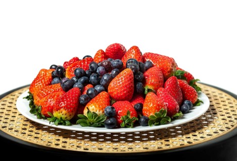 Three kinds of fresh berries on a white plate, on white background
