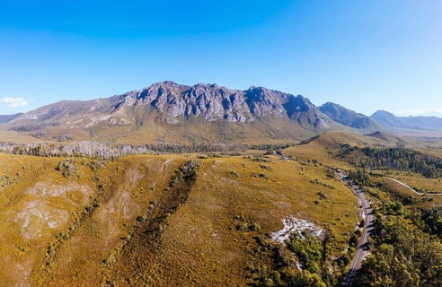 An aerial view of Gordon River Rd at the Sentinel range of mountains near Bitumen Bones Sculpture