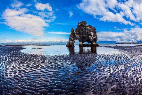 The north coast of Iceland. Ocean tide at sunset. Rock Hvitserkur on the sea beach in the form of a