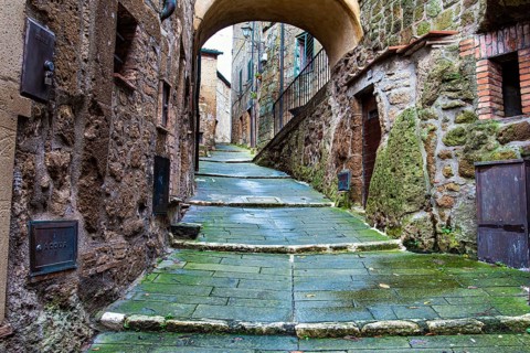 The tuff city of Sorano. Narrow street and covered bridge. Etruscan towns of Tuscany. Towns that