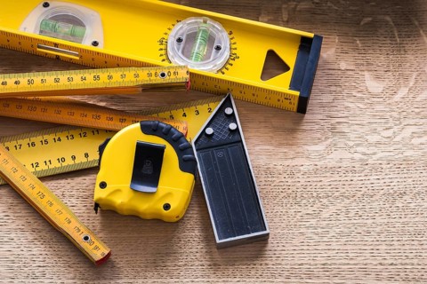 Oaken board with wooden meter measuring line construction level and square ruler maintenance