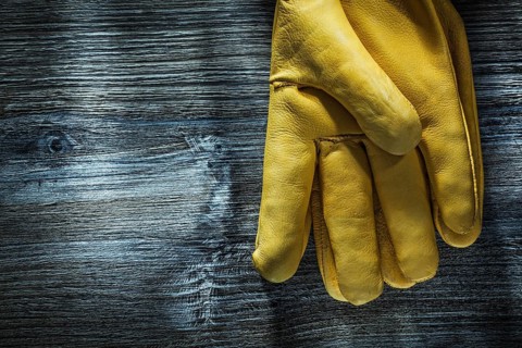 Pair of safety gloves on wooden board