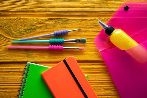 Back to school supplies arrangement vivid colorful neon color on yellow