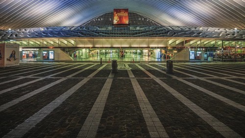 Architecture and entrance of a railway station at night, illuminated and symmetrical,