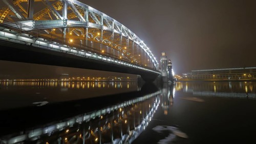 Illuminated Peter the Great Bridge across Neva River in night Saint Petersburg, Russia, Europe