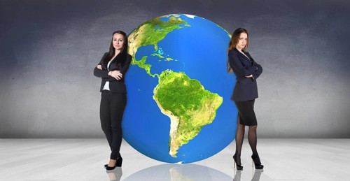 Business women stands near big earth ball in the gray room.Elements of this image furnished by NASA