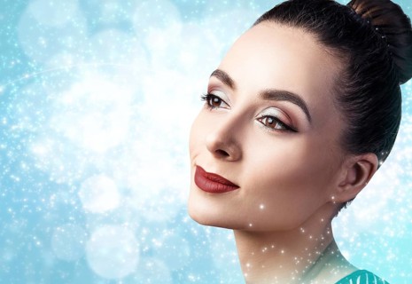 Portrait of young and beautiful woman with evening make-up over winter Christmas background