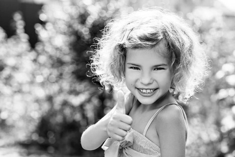 Cute little girl smiling in the park in summer day