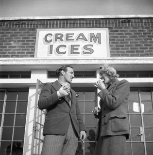 Icecream in the 1940s. A young couple in front of a ice cream shop. UK 1945. Kristoffersson ref