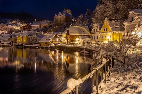 Winter view of Cesky Krumlov, picturesque houses under the castle with snow-covered roofs. Narrow