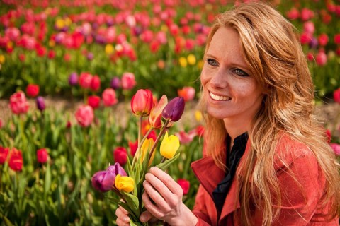 Portrait of a beautiful blond Dutch girl in tulips field